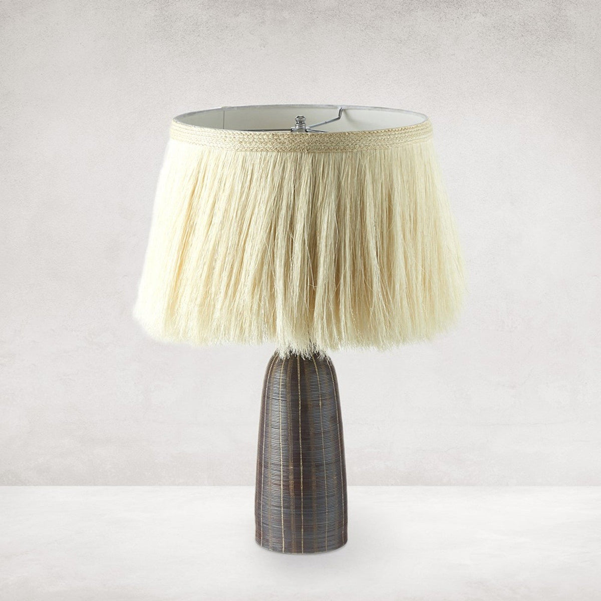 Sisa Table Lamp illuminated, showing the handpainted ceramic base and textured ivory shade